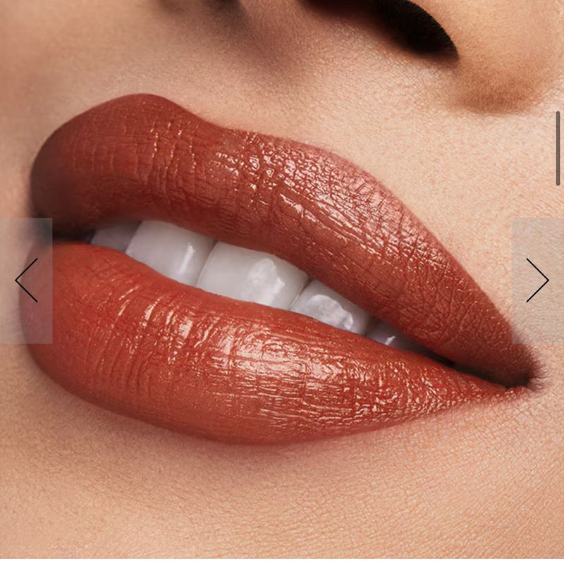 Close-up studio shot of a woman's face, focusing on glossy terracotta lipstick, showcasing makeup and beauty products for cosmetics advertising.