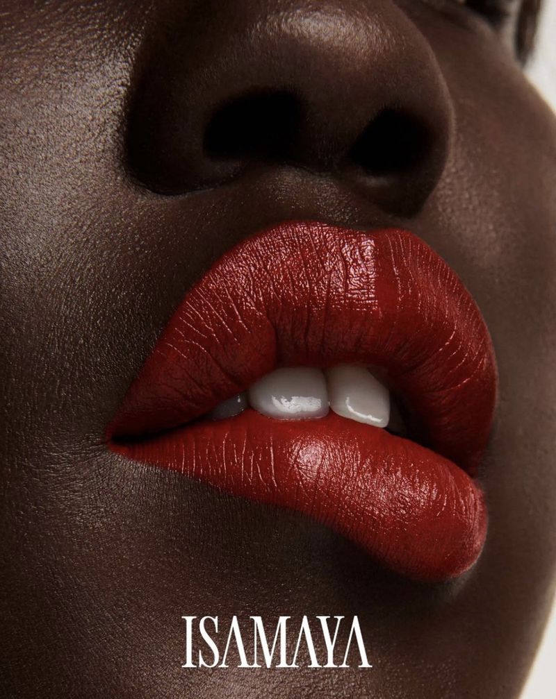Close-up of a dark-skinned woman with red lipstick, showcasing the texture and color. Cosmetic beauty product for makeup.