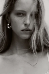 Close up portrait of model Abby Champion wearing silver hoop earrings for an H and M lingerie campaign