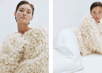 Model wearing a textured cream sweater with a slicked-back hairstyle against a clean white background