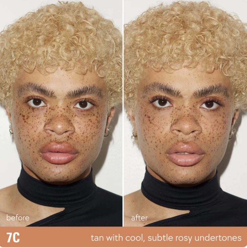Close-up split screen of a person's face before and after makeup. The person has freckles and curly blonde hair, and is wearing a black top.