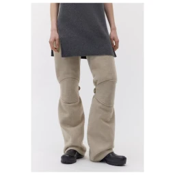Model wearing a dark grey knit tunic and beige trousers with reinforced knee panels against a white background.