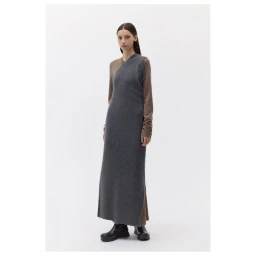 Model standing on white studio floor wearing a sleeveless charcoal grey dress over brown long-sleeve top.