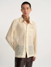 Model wearing a cream patterned lace shirt and brown trousers against a white backdrop for Séfr ecommerce