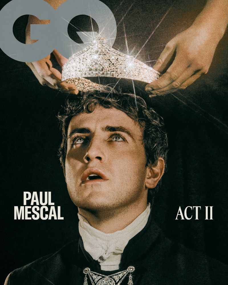 Paul Mescal poses for the cover of GQ with a crown being placed above his head. He wears a white shirt and a dark coat.