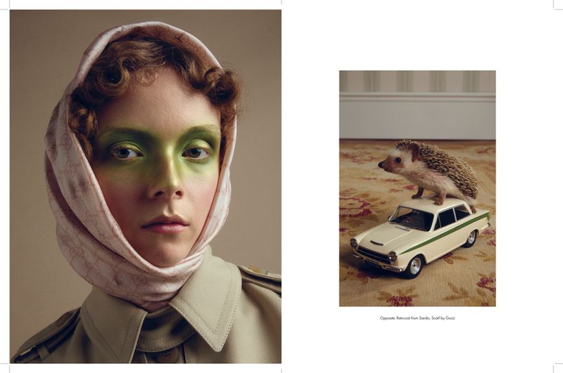 Close-up of a woman with green makeup and a headscarf next to a hedgehog toy on top of a toy car on a floral rug.