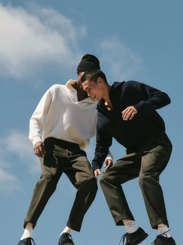Two male models in collared sweaters and trousers posing against a bright clear sky for Massimo Dutti