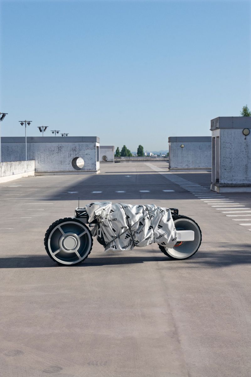 Conceptual self-driving vehicle prototype on a concrete rooftop parking lot under a clear sky, showcasing unique design and futuristic technology.