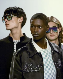 Three male models wearing designer sunglasses and apparel for Louis Vuitton Spring 25 Capsule against a neutral background
