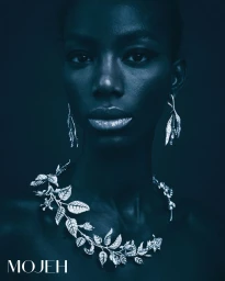 Close-up portrait of a Black woman wearing silver leaf jewelry and a dark blue-toned tone for Mojeh Magazine