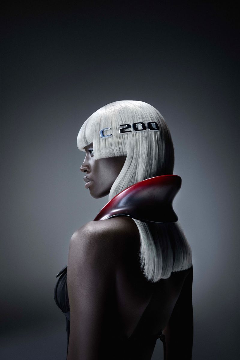 Striking beauty portrait of an adult woman with white hair, wearing a red collar, against a grey background, featuring 'C 200' text.