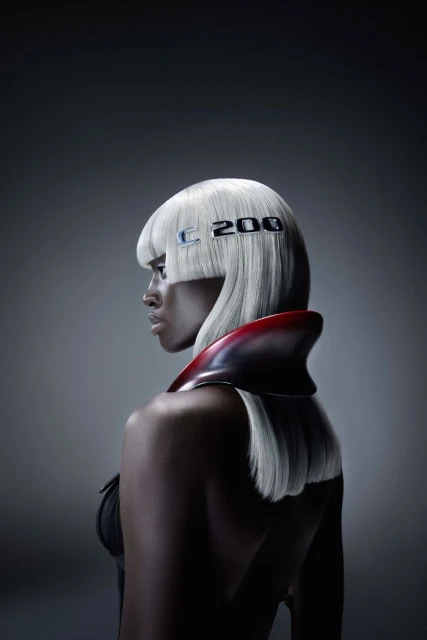 Striking beauty portrait of an adult woman with white hair, wearing a red collar, against a grey background, featuring 'C 200' text.