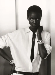 Model in white collared shirt wearing chunky silver cuffs and a black belt against a white seamless backdrop