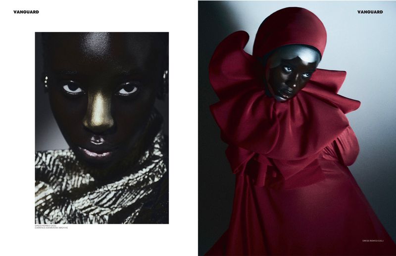 Close-up fashion shot of a Black female model with silver makeup and dark clothing alongside a woman in a red sculptural outfit.