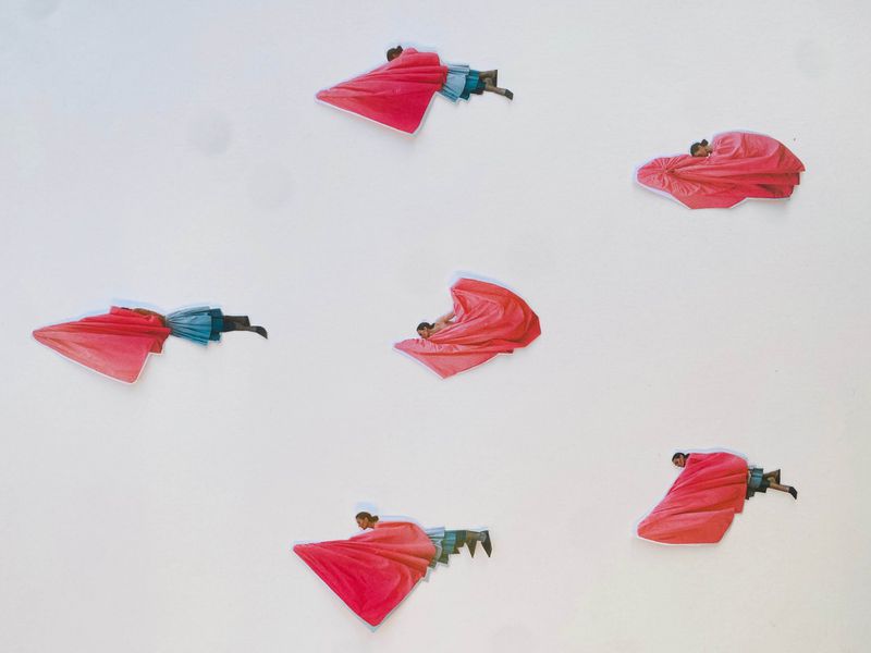 Collage of figures in red draped fabric against a white background, artistic and abstract. Contemporary aesthetic with cut-and-paste elements.