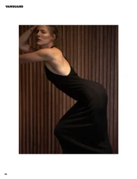 Woman in a black dress leaning against a vertical wood panel wall for Vanguard Magazine Beyond Linear editorial