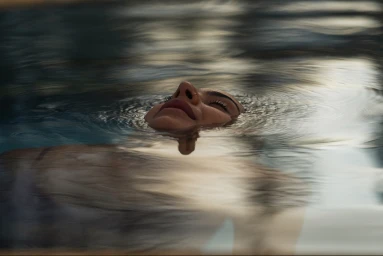 Close-up of a person floating peacefully in thermal water with gentle ripples at Opuke Thermal Pools and Spa.