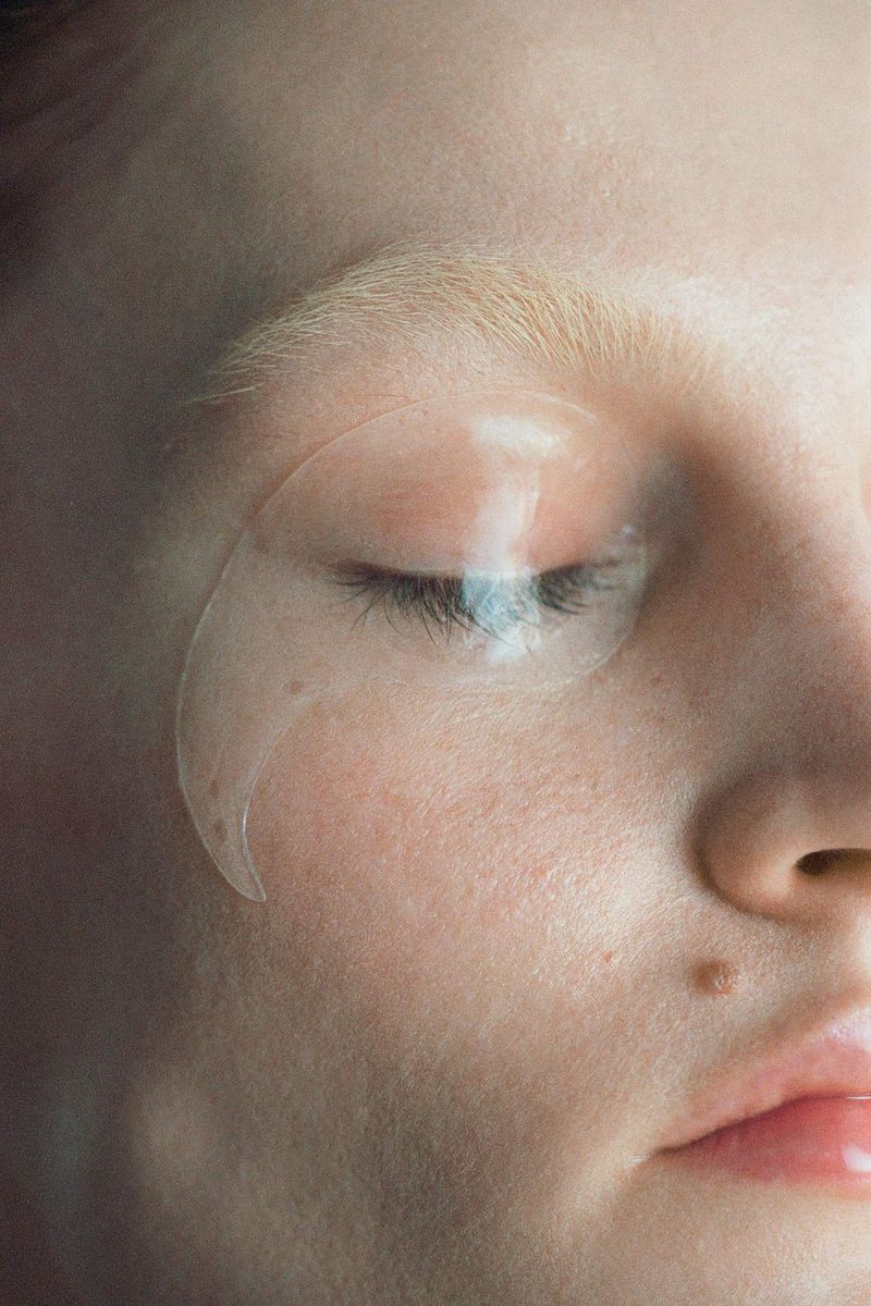 Close up portrait of a woman with an eye mask, fair skin, and blonde hair, featuring soft lighting for skincare or beauty concept.