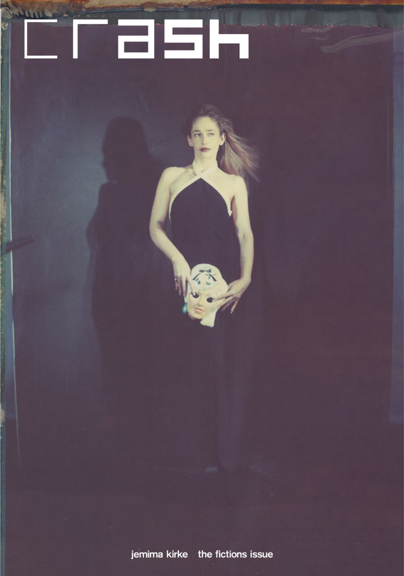 CRASH magazine cover features a woman holding a doll mask in a dark studio, wearing a black dress against a muted, moody backdrop.