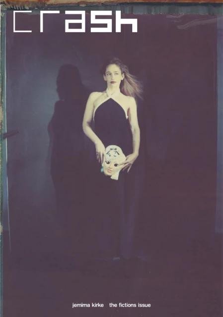 CRASH magazine cover features a woman holding a doll mask in a dark studio, wearing a black dress against a muted, moody backdrop.