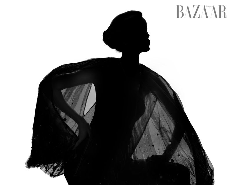 Silhouette of a woman in a flowing gown, posing against a bright white background, with the 'BAZAAR' logo in the upper right corner.