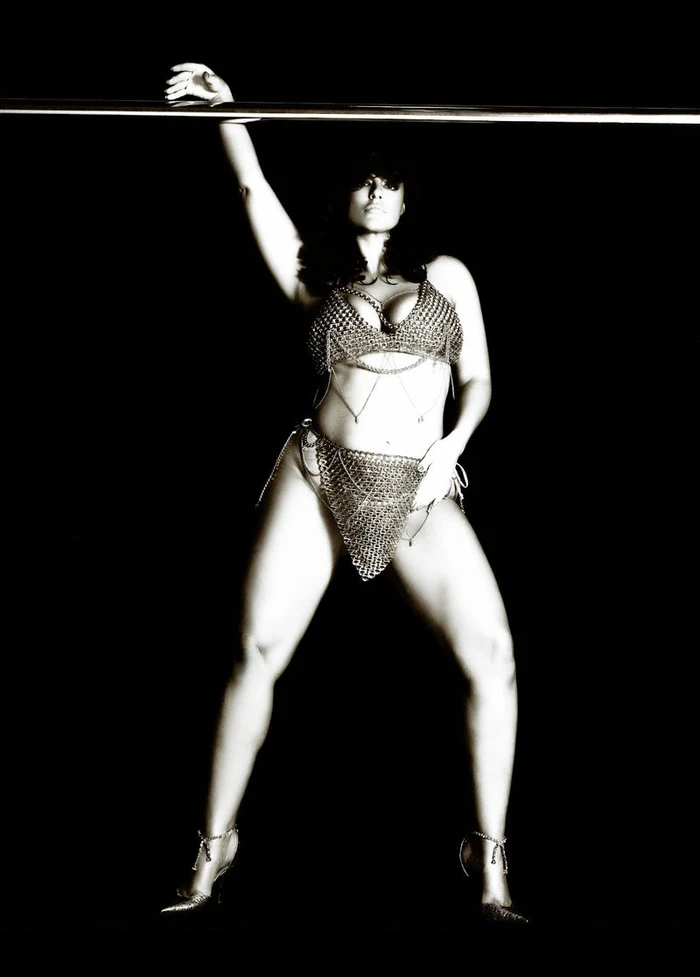 Model Ashley Graham wearing a chainmail lingerie set against a solid black background for V Magazine
