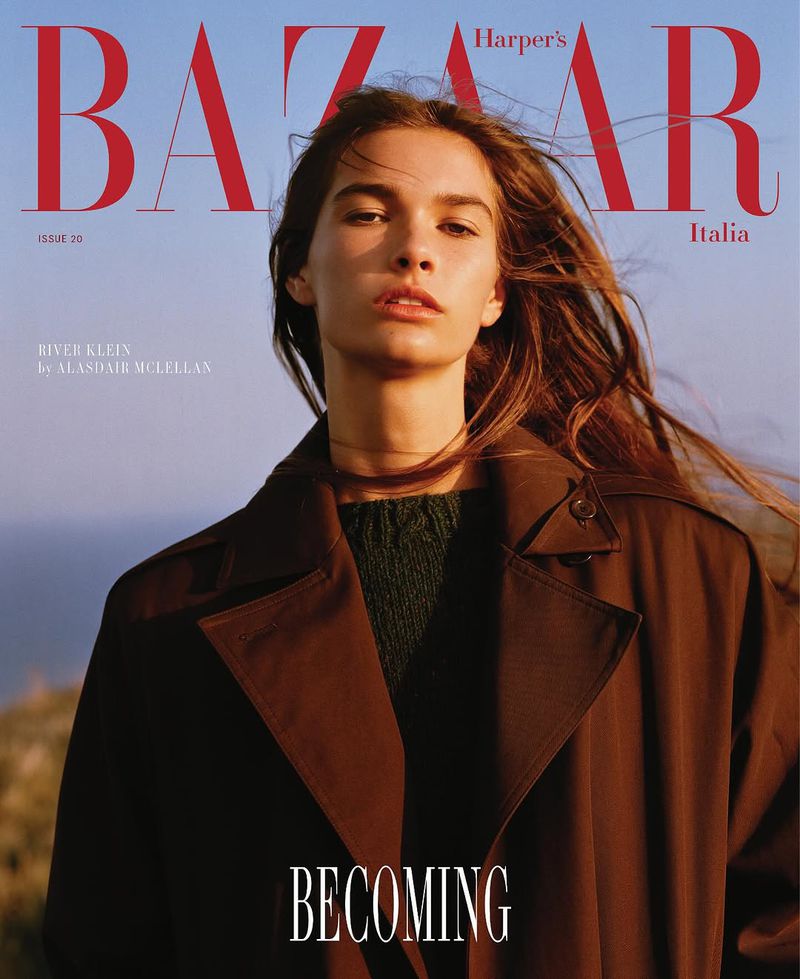 Harper's Bazaar Italia magazine cover featuring a portrait of a young adult female model wearing a brown trench coat in natural light.