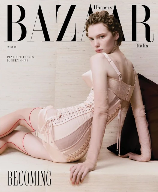 Fashion editorial cover shot for Harper's Bazaar Italia featuring a young adult female model in a corset posing on a neutral surface.