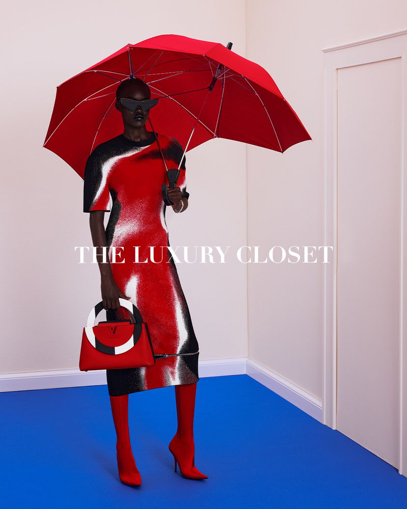 A fashion shot features a Black model in a red-and-black dress, red stockings, and heels, holding a purse and a matching red umbrella.
