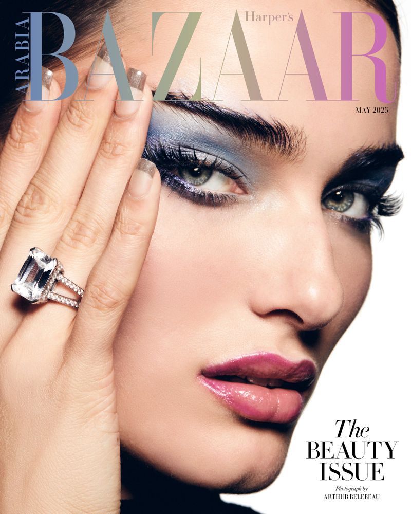 Beauty editorial shot of a woman with blue eye shadow and a large diamond ring for Harper's Bazaar magazine cover, May 2025 issue.