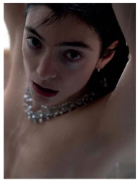 Close-up portrait of Lorde with wet hair, wearing a statement silver necklace and posing for Re-Edition Magazine.