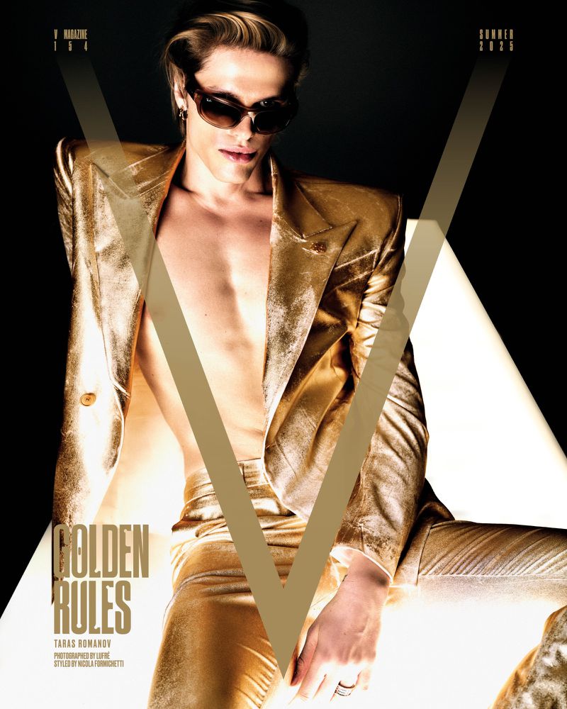 Fashion editorial shot of a fair-skinned male model with sunglasses, wearing a gold suit in front of a black and white backdrop.