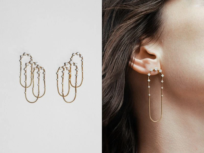 Elegant gold earrings with diamonds are displayed on a white surface and worn by a woman, showcasing jewelry design and fashion.