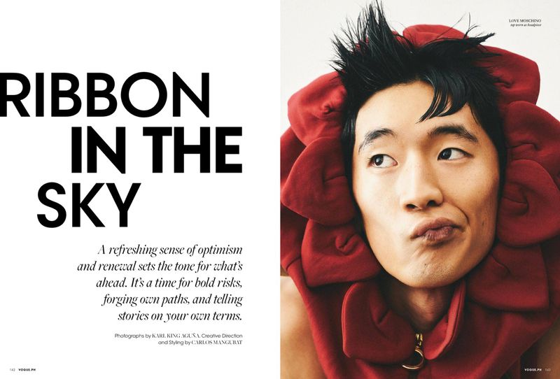 Close-up of an Asian male model in a red flower-like hood, contrasted against magazine text. Fashion and portrait photography in studio lighting.