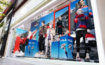 Retail storefront window display featuring FILA China sportswear apparel, mannequins, and promotional graphics.