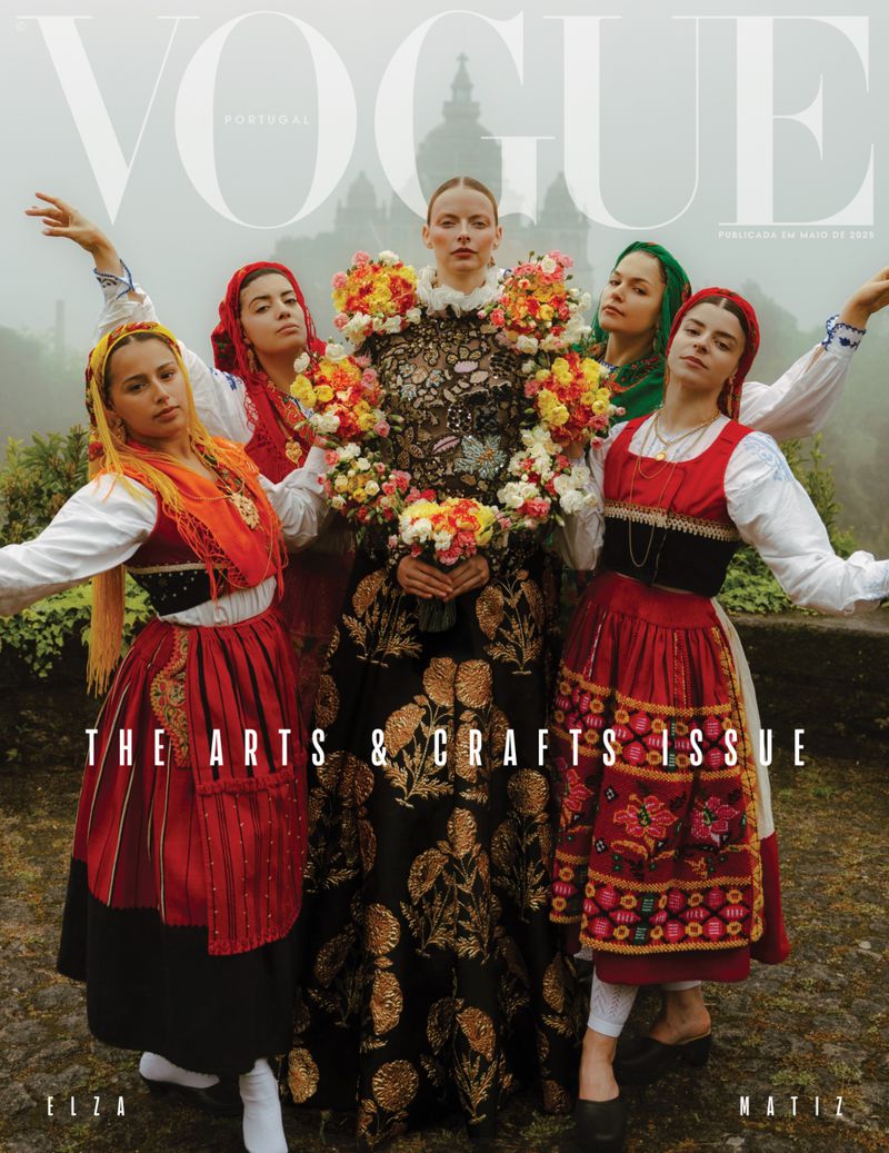 Vogue cover featuring five women in traditional folk costumes, centered around a woman adorned with a floral wreath, castle backdrop.