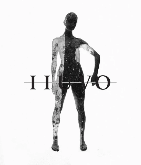 Abstract monochrome studio shot of a person with tattoos, split into light and dark halves, standing against a bright white background.