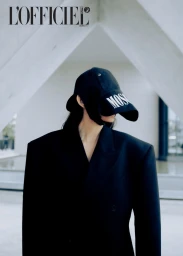 Model in oversized black blazer wearing a baseball cap pulled down over eyes for L'Officiel Baltics Mirror Mirror editorial