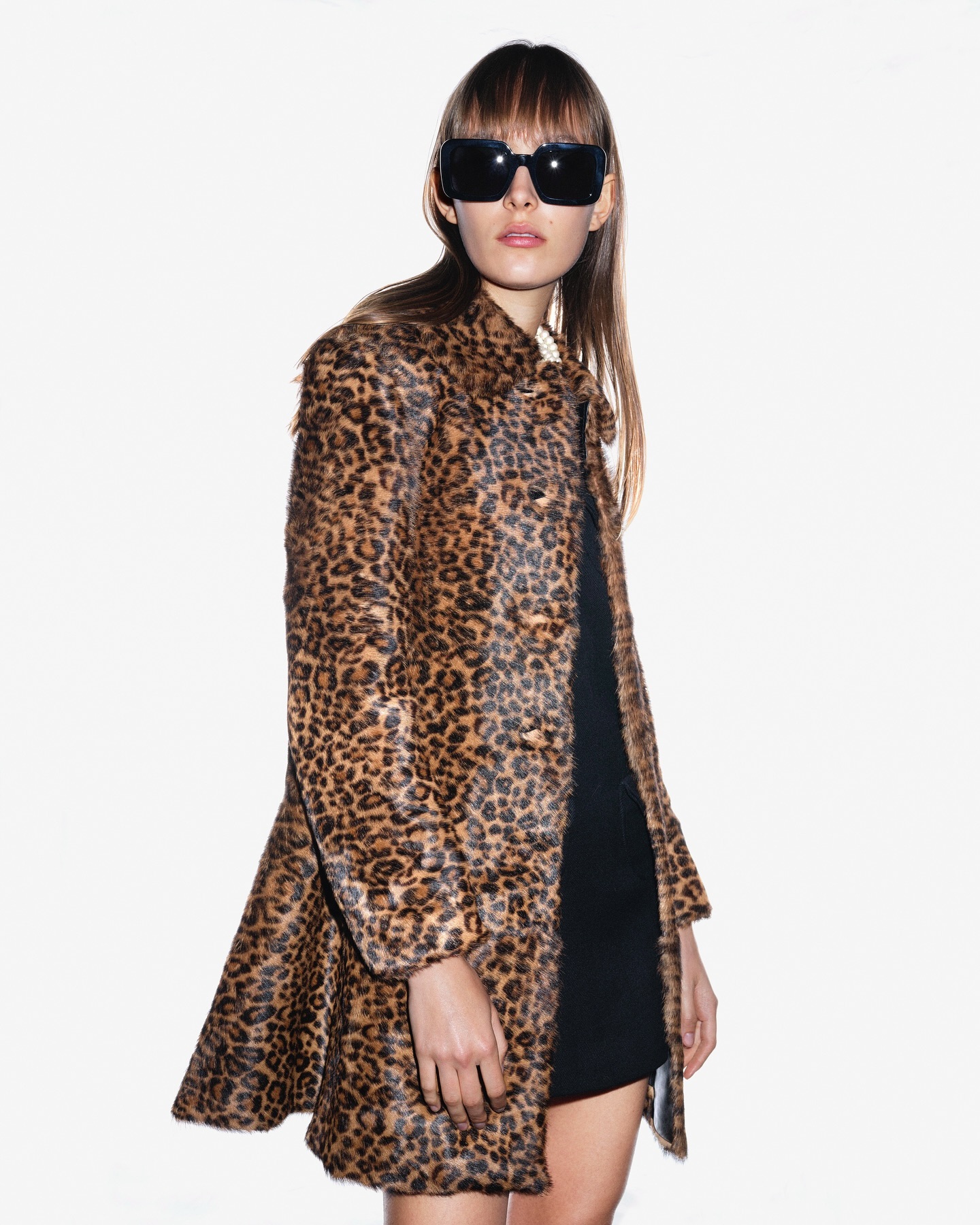 Model wearing dark sunglasses and a leopard print coat against a plain white background for Side-note