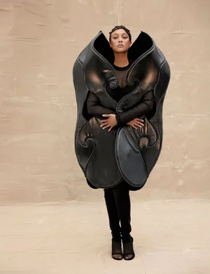 Tyra Banks wearing an oversized sculptural black garment against a neutral textured backdrop for Numero Netherlands.