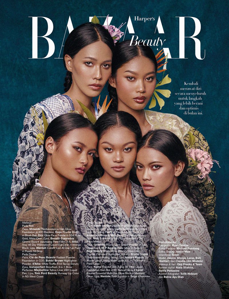 Magazine cover featuring five women with flowers in their hair, adorned in traditional-patterned tops, set against a teal background.