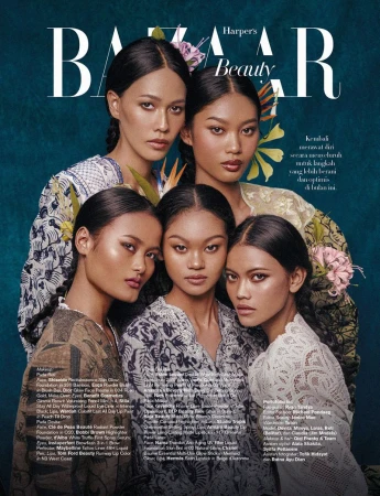 Magazine cover featuring five women with flowers in their hair, adorned in traditional-patterned tops, set against a teal background.