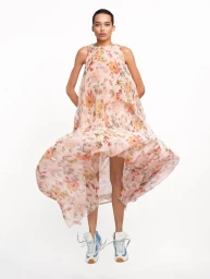 Model Lara Menezes wearing a floral print dress and sneakers against a white background for Re-Edition Magazine