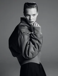Model wearing a dark bomber jacket against a plain grey background for Re-Edition Magazine