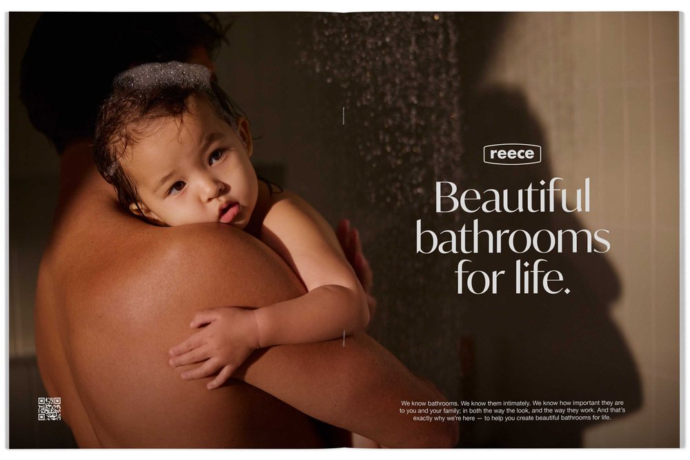 An advertisement for Reece featuring a baby with wet hair being held by an adult, against a backdrop of a shower and bathroom text.