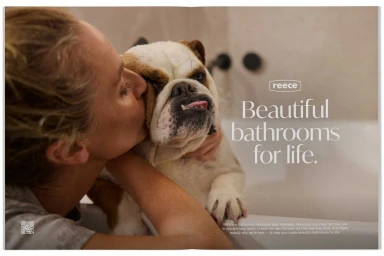 Woman kissing an English Bulldog by a bathtub in a bathroom, for the Reece Beautiful Bathrooms campaign photographed by Chris Searl.