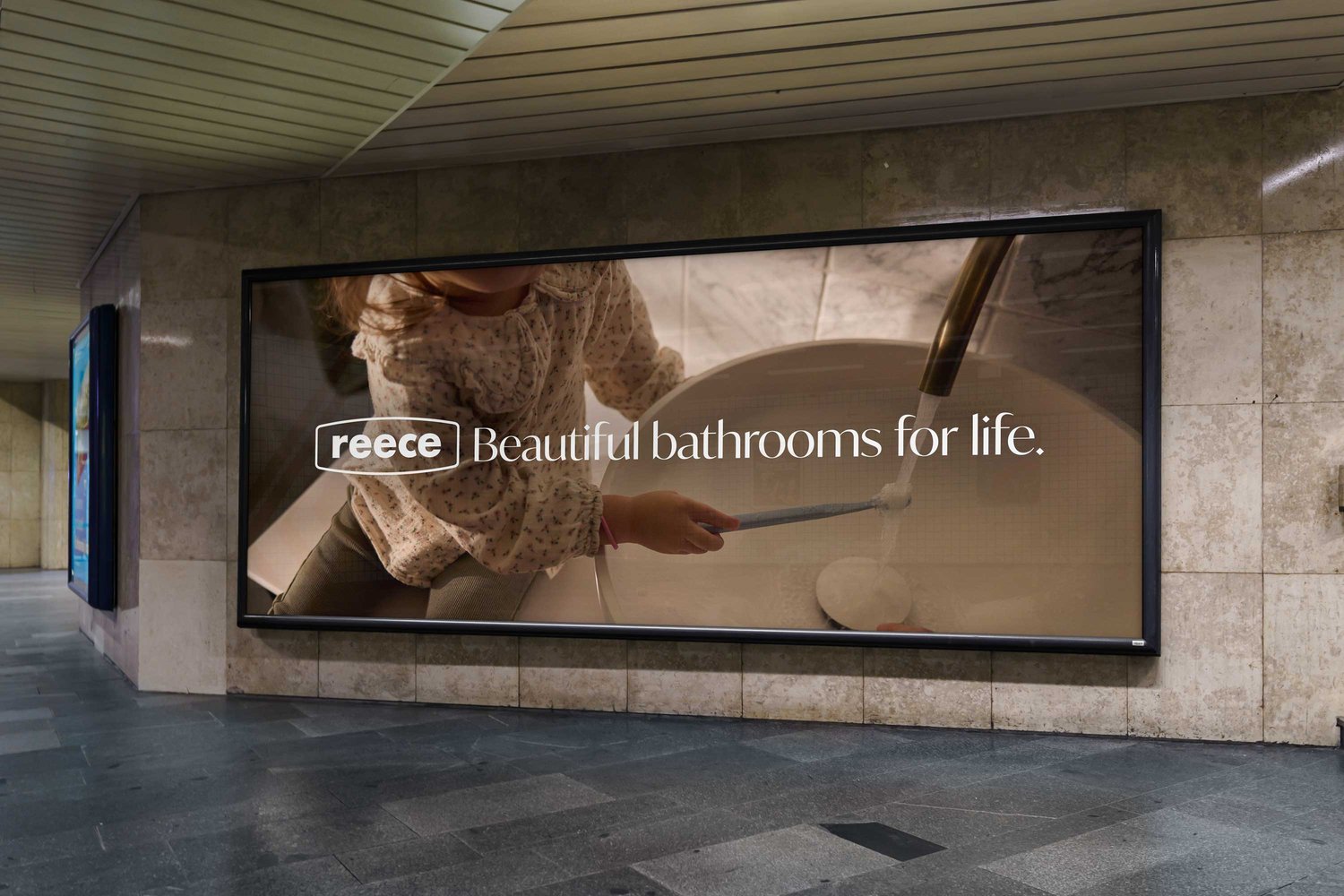 Reece ad in subway shows a child by a bathroom sink with the tagline: Beautiful bathrooms for life. The ad is set in a subway.