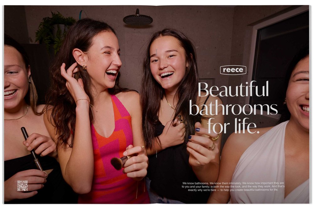 Advertisement featuring four young adult women laughing in a bathroom setting, promoting Reece bathrooms with bright lighting and cheerful mood.