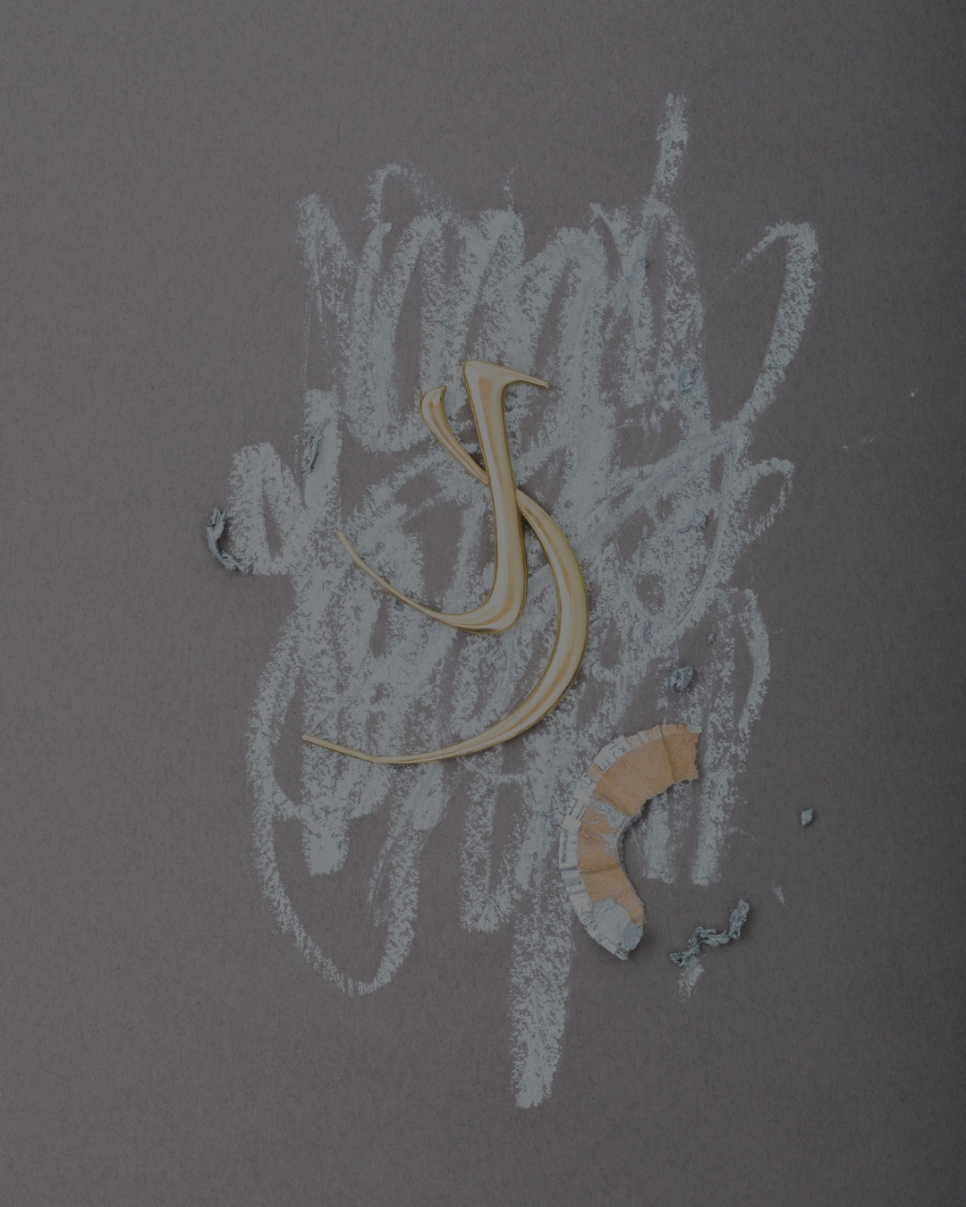 Stylized letter 'S' crafted from metal on a gray background with chalk scribble marks and broken pencil shaving, artful composition.
