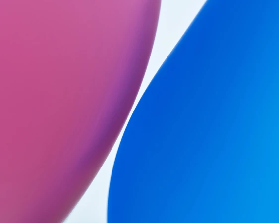 Abstract close-up of pink and blue balloon surfaces against a white background with no visible text or other objects in the frame.